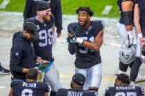 Raiders defensive end Malcolm Koonce (51) retells a play to defensive end Maxx Crosby (98) and ...